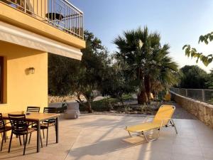 un patio avec une table et des chaises à côté d'un bâtiment dans l'établissement Minoa apartment in the heart of a Cretan village, à Atsipopoulo