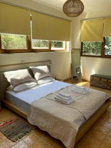 a bedroom with a large bed with towels on it at Minoa apartment in the heart of a Cretan village in Atsipopoulo
