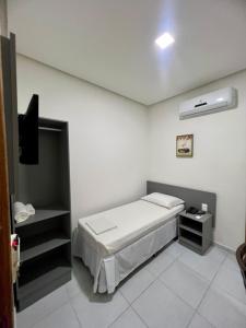 1 dormitorio con 1 cama y TV. en Destak Hotel Residence, en Palmares