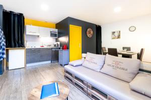 a living room with a couch and a kitchen at LE CÔTÉ COUR in Rodez