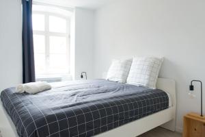 una camera bianca con un letto con una coperta blu di La Pomme Du Président II a Sélestat