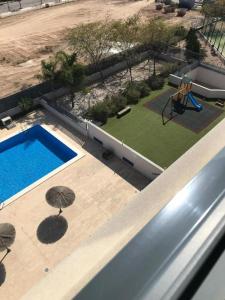een uitzicht op een zwembad en een speeltuin bij Apartamento DALÍ in Murcia