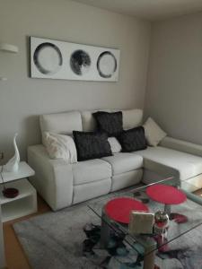 a living room with a white couch and two pictures on the wall at Apartamento DALÍ in Murcia