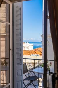 a balcony with a table and a view of the ocean at Archontiko Eleni Hotel in Andros