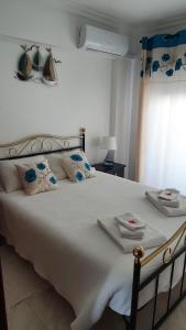 een slaapkamer met een groot wit bed en handdoeken bij Quarteira Beach in Quarteira