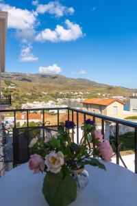 a vase of flowers sitting on a table on a balcony at Archontiko Eleni Hotel in Andros