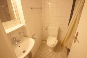 a white bathroom with a toilet and a sink at Swiss Star Basel Schweizergasse - Self Check-In in Basel