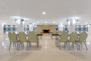 a dining room with chairs and tables and a piano at Daniya Denia Spa & Business 4* in Denia