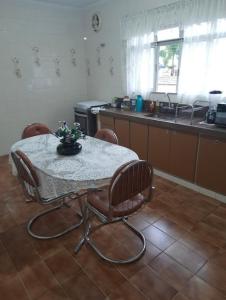 uma cozinha com uma mesa e cadeiras com uma mesa e um balcão em Casa no Centro de Serra Negra em Serra Negra