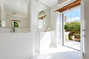 uma casa de banho com um lavatório e uma grande janela em THE OLIVE MILL GUEST HOUSE em Lefkes