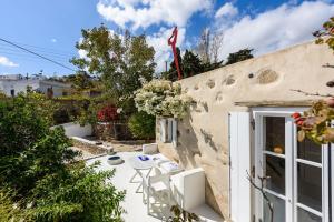 THE OLIVE MILL GUEST HOUSE في Lefkes: فناء مع طاولة وكراسي بجوار مبنى