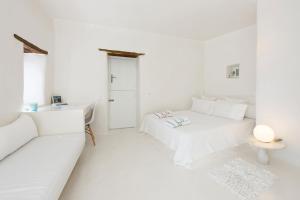 a white room with two beds and a couch at THE OLIVE MILL GUEST HOUSE in Lefkes