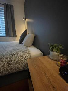 um quarto com uma cama com almofadas e uma mesa em Le Revella em Profondeville