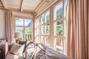a living room with a couch and a large window at Casa Eth Mur by Totiaran in Naut Aran