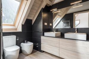 a bathroom with two sinks and a toilet at Casa Eth Mur by Totiaran in Naut Aran