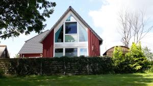 a red and white house with a large window at Kapitänshaus - Atelier in Ahrenshoop