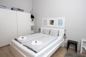 biała sypialnia z białym łóżkiem i ręcznikami w obiekcie Jet Setter LUXURY apartment behind Opera house at the famous Andrassy avenue w Budapeszcie