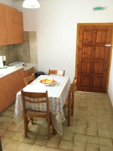 a kitchen with a table with chairs and a kitchen door at ARISTIDIS APARTM. 2 in Kavos