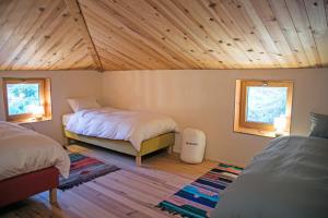 sypialnia z dwoma łóżkami i drewnianym sufitem w obiekcie Eco lodge Carbonaccio w mieście Chiatra