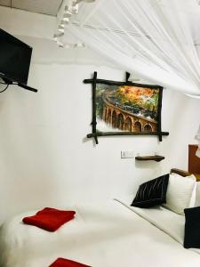 een kamer met een bed en een schilderij aan de muur bij Ella HIDE VIEW in Ella