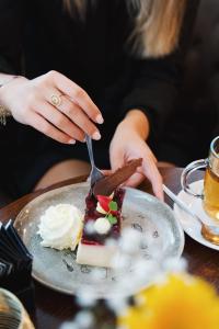 una mujer comiendo un trozo de pastel en un plato en Hotel de Wijnberg en Bolsward