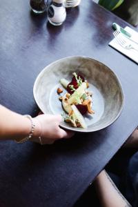 uma pessoa que segura um prato de comida numa mesa em Hotel de Wijnberg em Bolsward