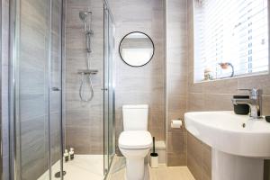 a bathroom with a shower and a toilet and a sink at Luxury Show Home in Prime Location - Sleeps up to 6 Guests - Free Parking, Fast Wifi, SmartTV with Netflix and Private Garden by Yoko Property in Milton Keynes