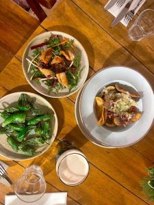 trzy talerze jedzenia na drewnianym stole w obiekcie The Golden Cross w mieście Cirencester