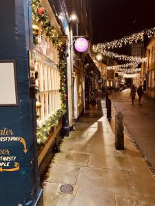 a street at night with Christmas lights on the building w obiekcie The Golden Cross w mieście Cirencester