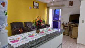 una sala de estar con una mesa con flores. en Apto completo no centro 2qtos - Residencial Ponta Verde., en Caldas Novas