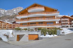 ein großes Apartmenthaus in den Bergen mit Schnee in der Unterkunft Aramis 1 in Leukerbad