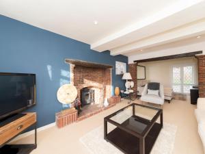 a living room with a fireplace and a tv at Pass the Keys Luxurious Country House with Cinema Games Room in Reading