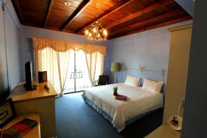 um quarto com uma cama branca e um lustre em The Colored House Jomtien em Praia de Jomtien