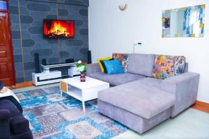 sala de estar con sofá y chimenea en The porch garden Estate 1 bedrm en Nairobi