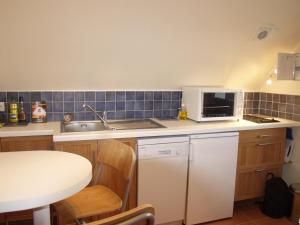 eine Küche mit einem weißen Kühlschrank und einer Mikrowelle in der Unterkunft Appartement Le Palais, 2 pièces, 2 personnes - FR-1-418-165 in Le Palais