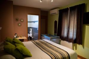 1 dormitorio con 1 cama grande y baño en Logis Hotel Restaurant L'Escapade, en Le Pêchereau