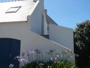 a white house with purple flowers in front of it at Appartement Le Palais, 2 pièces, 2 personnes - FR-1-418-165 in Le Palais