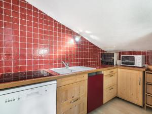 a kitchen with red tiles on the wall at Appartement Megève, 3 pièces, 5 personnes - FR-1-453-145 in Megève