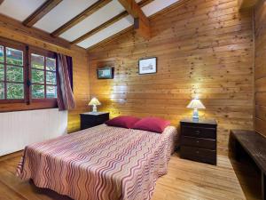 a bedroom with wooden walls and a bed with red pillows at Chalet Megève, 3 pièces, 4 personnes - FR-1-453-255 in Megève