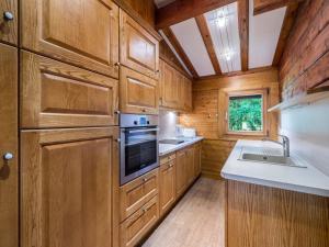 a kitchen with wooden cabinets and a sink and a stove at Chalet Megève, 3 pièces, 4 personnes - FR-1-453-255 in Megève