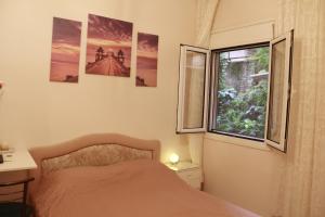 um quarto com uma cama e uma janela em Apartment Eirina em Atenas