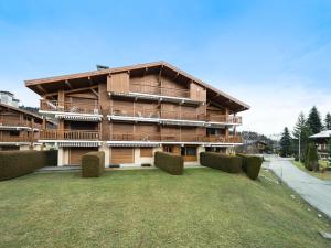 un grande edificio con un prato di fronte di Appartement Megève, 2 pièces, 4 personnes - FR-1-453-225 a Megève