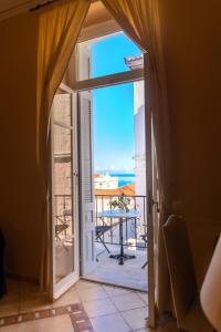 a door leading to a balcony with a view of the ocean at Archontiko Eleni Hotel in Andros