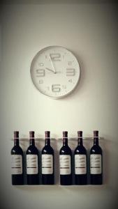eine Uhr und eine Reihe von Weinflaschen auf einem Regal in der Unterkunft City EPI-CENTER in San Sebastián