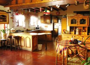 una cocina con armarios de madera y una mesa. en Hacienda El Pinar del Viento, en Villa de Leyva