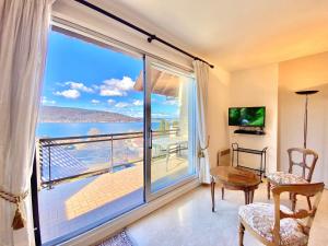 a room with a large window with a view of the ocean at F3 lumineux avec terrasse, parking et WiFi à Veyrier-du-Lac - FR-1-432-81 in Veyrier-du-Lac +7 photos