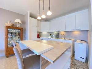 a kitchen with white cabinets and a table and a sink at F3 lumineux avec terrasse, parking et WiFi à Veyrier-du-Lac - FR-1-432-81 in Veyrier-du-Lac