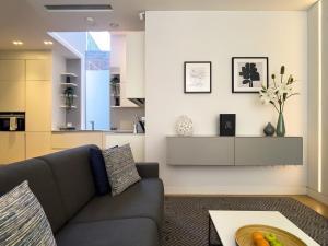 a living room with a couch and a table at Mirabilis Apartments - Bayham Place in London