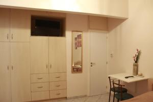 1 dormitorio con armarios blancos, escritorio y cama en Apartment Eirina en Atenas