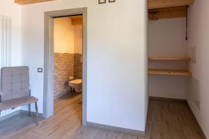 a room with a white wall and a chair and a table at Residenza al Castello in Enguiso +87 photos